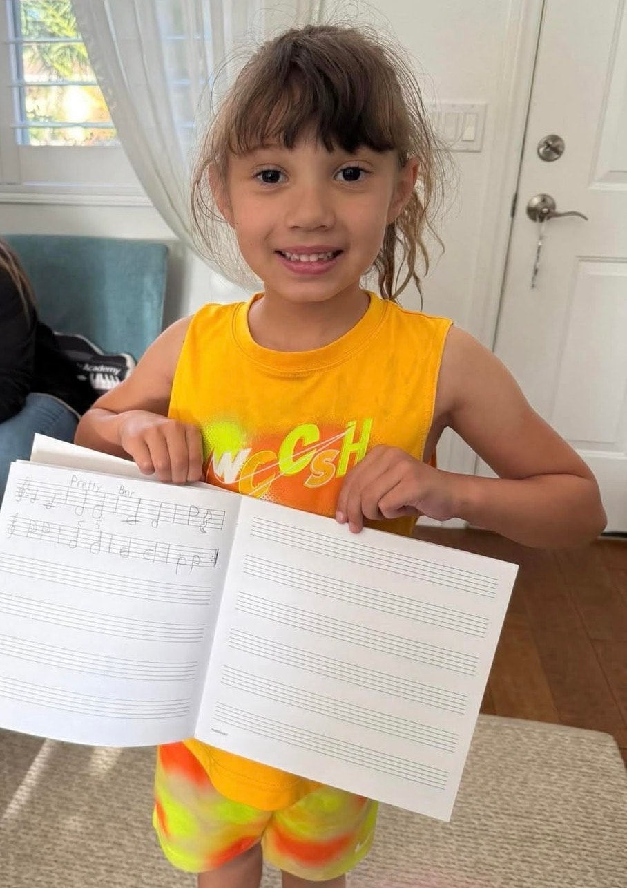 Young songwriter holding a notebook with her handwritten music